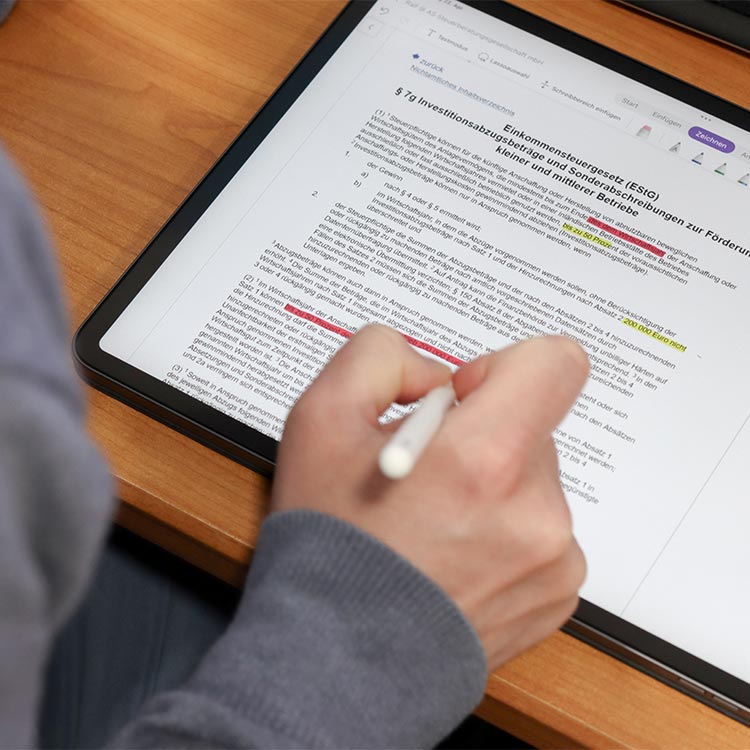 Person bearbeitet einen Text am Tablet